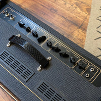 Close up view of top of Vox AC15 Custom Twin Combo Amplifier on wooden floor with rug on the side