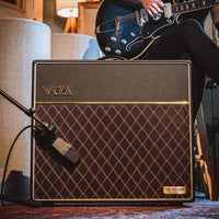 Front view of a miked Vox AC15 Hand-Wired Guitar Amplifier with guitarist in the background in studio