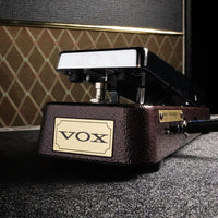 Front view of Vox V863-CA Auto Wah Pedal with guitar amplifier in the background on grey carpet