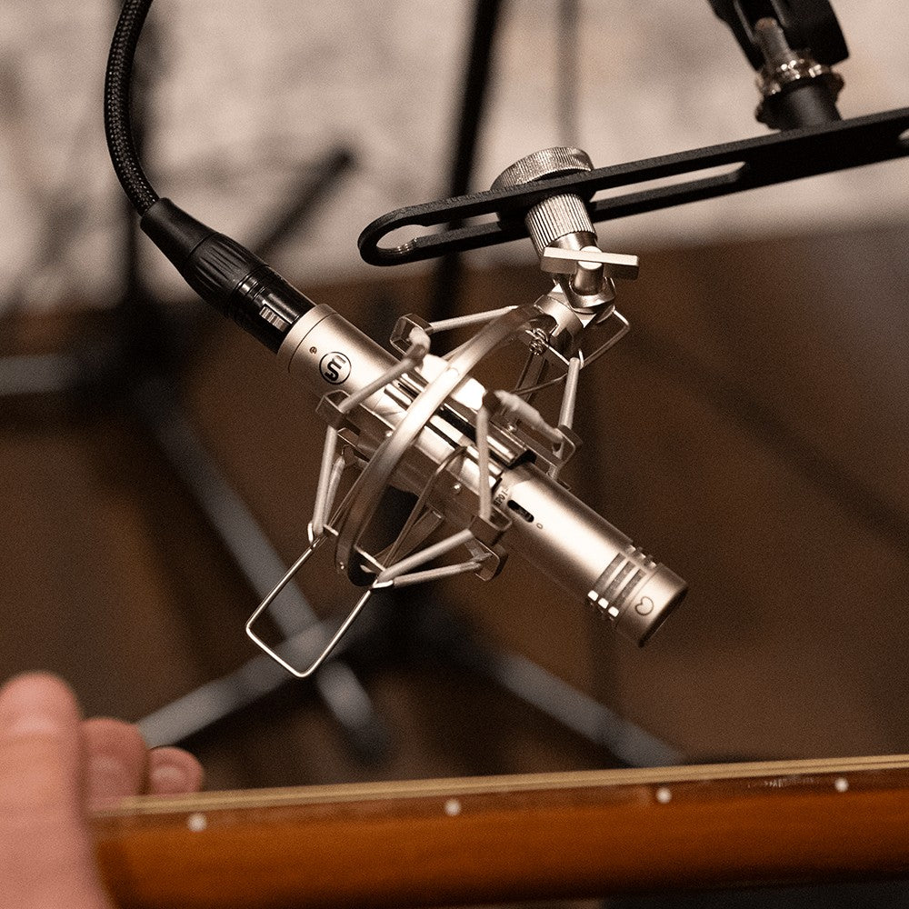 Angled view of mounted Warm Audio WA 84 Microphone Nickel recording an acoustic guitar in studio